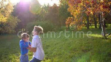 一个青少年和一个孩子玩，把他抱在怀里，吐出来。 阳光透过孩子. 他的笑声和欢乐